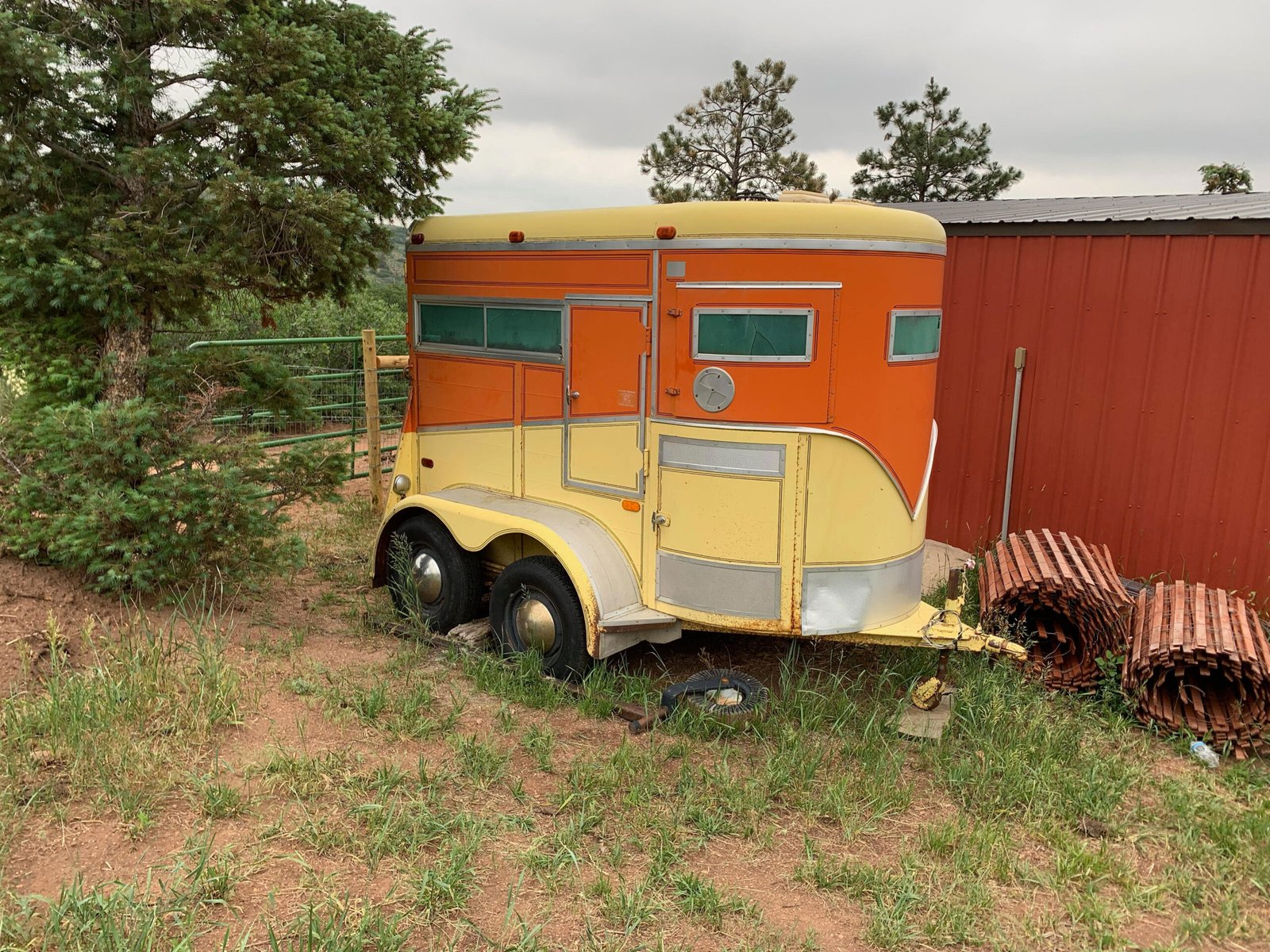 The orange and yellow 1973 Murdoch horse trailer before restoration.
